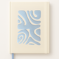 Notebook with a blue abstract design on a beige cover against a white background